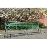 A large riveted strapwork iron garden bench, first half of the 19th century, with scrolling arms and