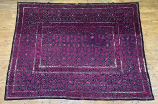 A large Turkoman Suzani wall hanging, circa 1900, the purple ground embroidered with interlaced