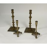 Two pairs of brass candlesticks, late 18th century: the smaller pair with faceted cups over square