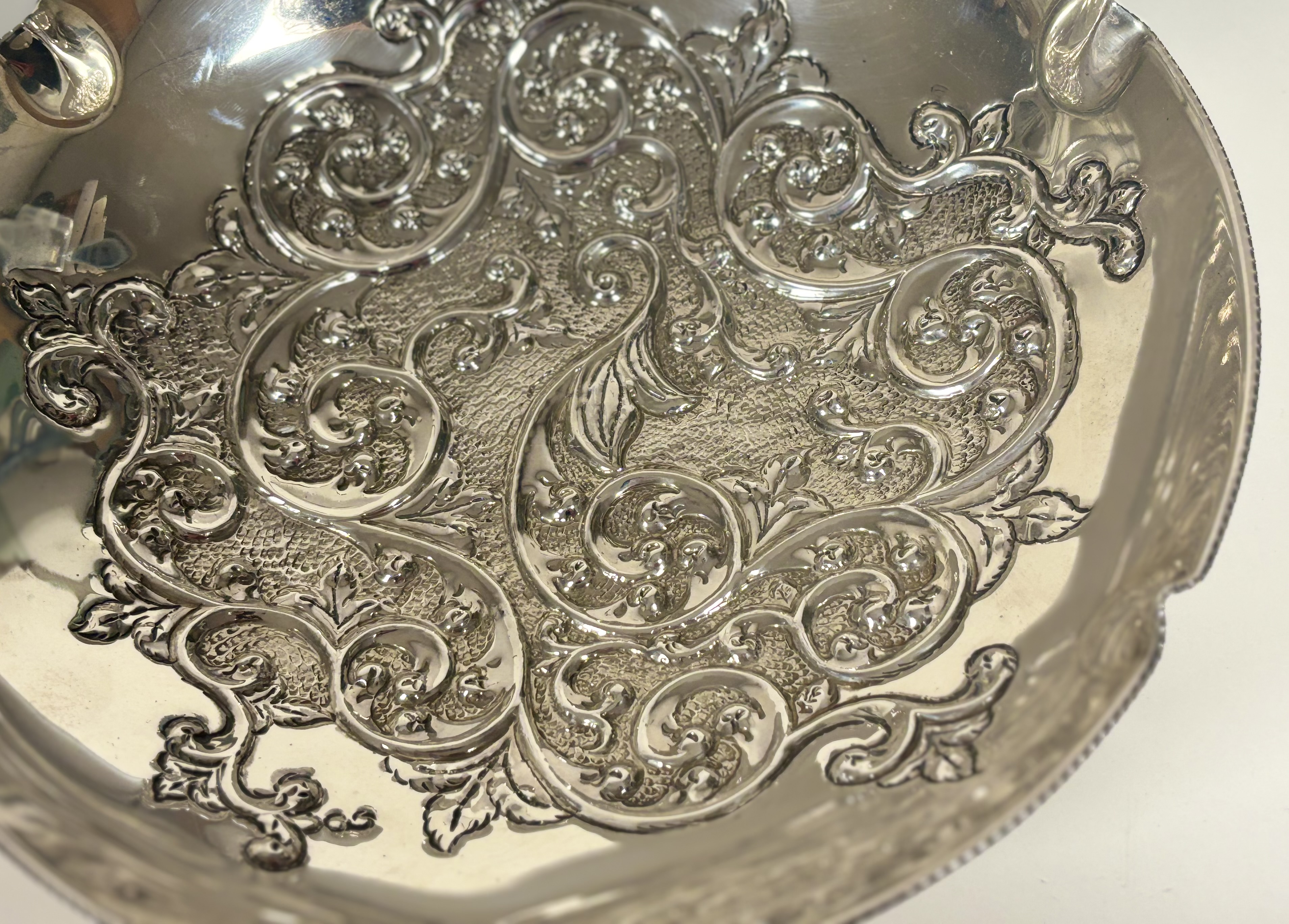 A Continental silver centre bowl, circular, the well repousse with scrolling foliage, raised on