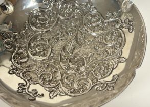 A Continental silver centre bowl, circular, the well repousse with scrolling foliage, raised on