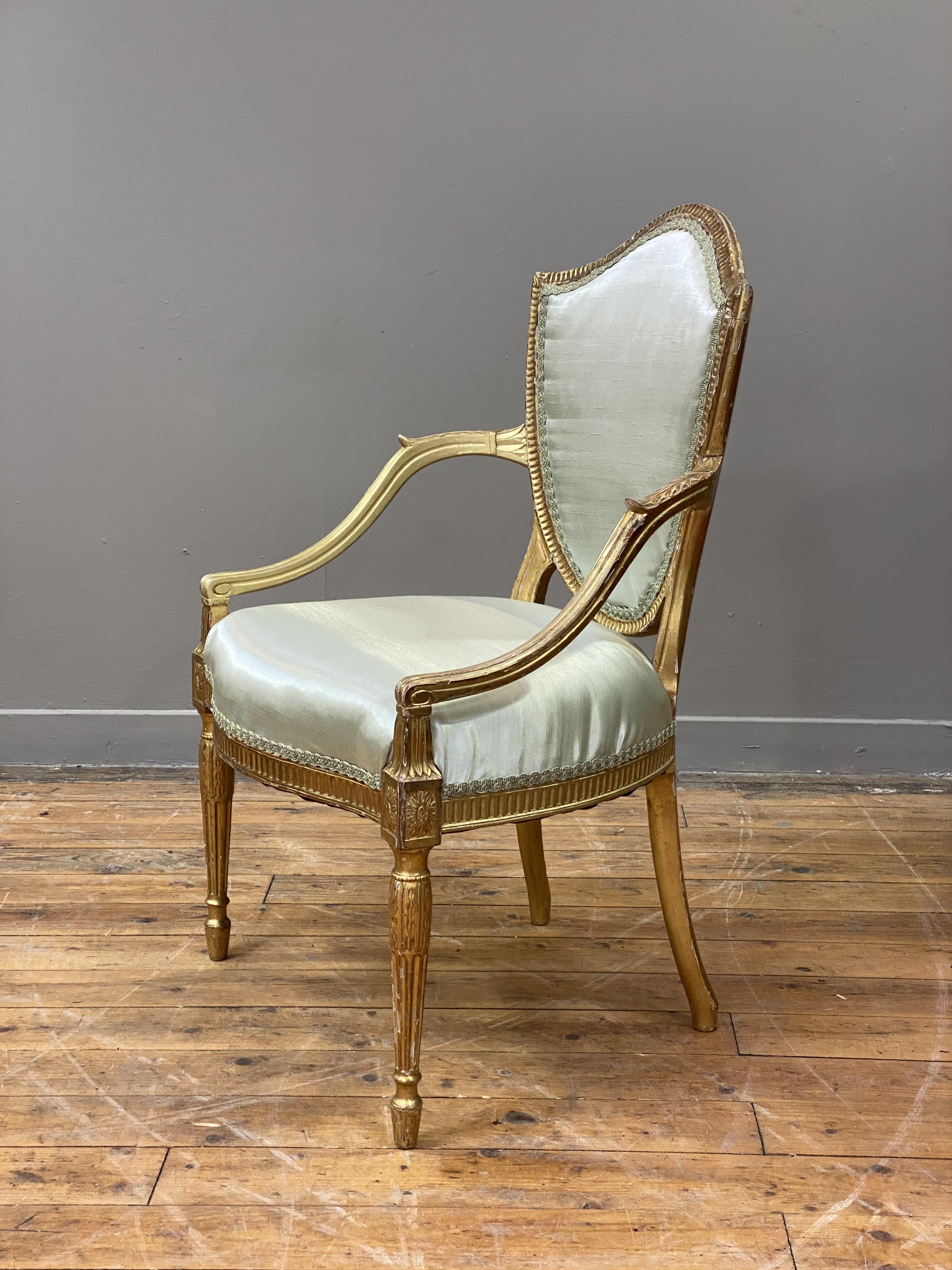 A George III giltwood and gesso elbow chair in the manner of Thomas Hepplewhite, late 18th