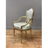 A George III giltwood and gesso elbow chair in the manner of Thomas Hepplewhite, late 18th