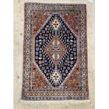 A hand knotted Persian style rug, decorated with geometric floral motifs and stylised animals. 130cm