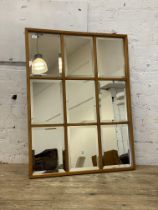 A pine framed sectional wall mirror with nine bevelled plates. 110cm x 83cm.
