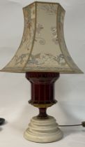 A gilt painted ruby glass table lamp, fitted with two branches and raised on a turned base, complete