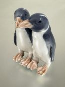A Danish Royal Copenhagen figure group of two Galapagos penguin chicks decorated with polychrome