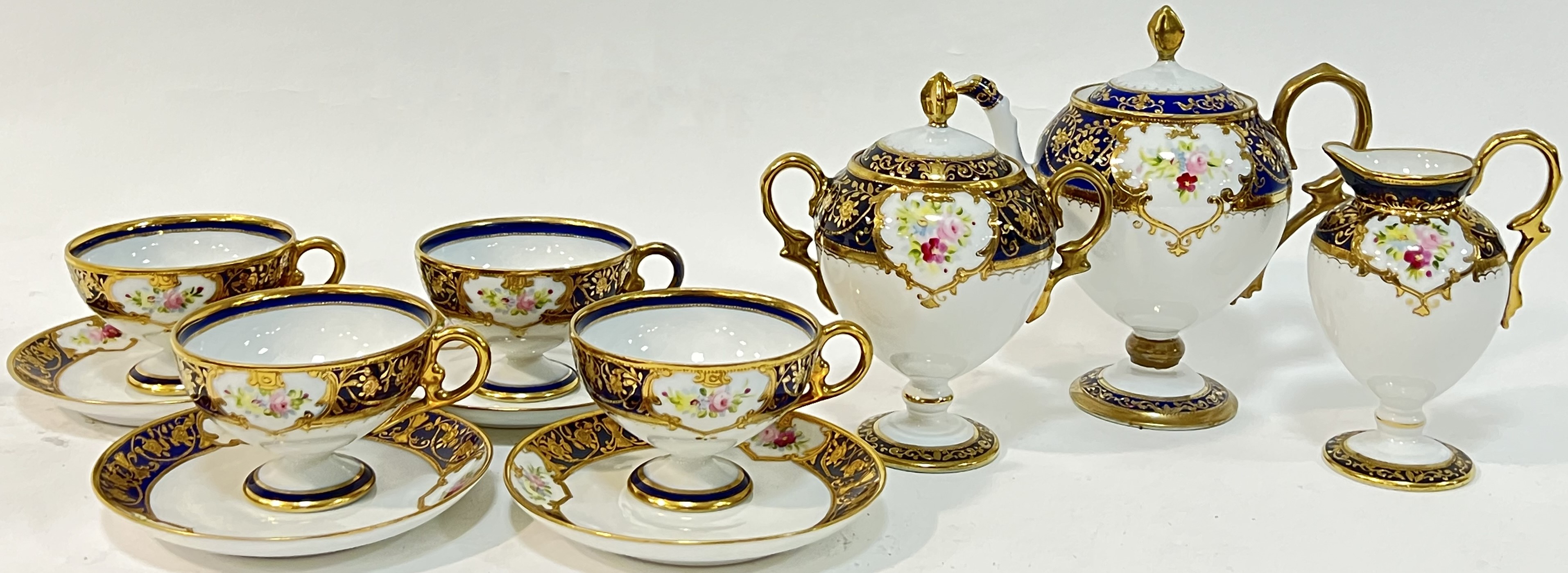 A Japanese Noritake fine porcelain tea or coffee set with blue and gilt decoration and enamelled