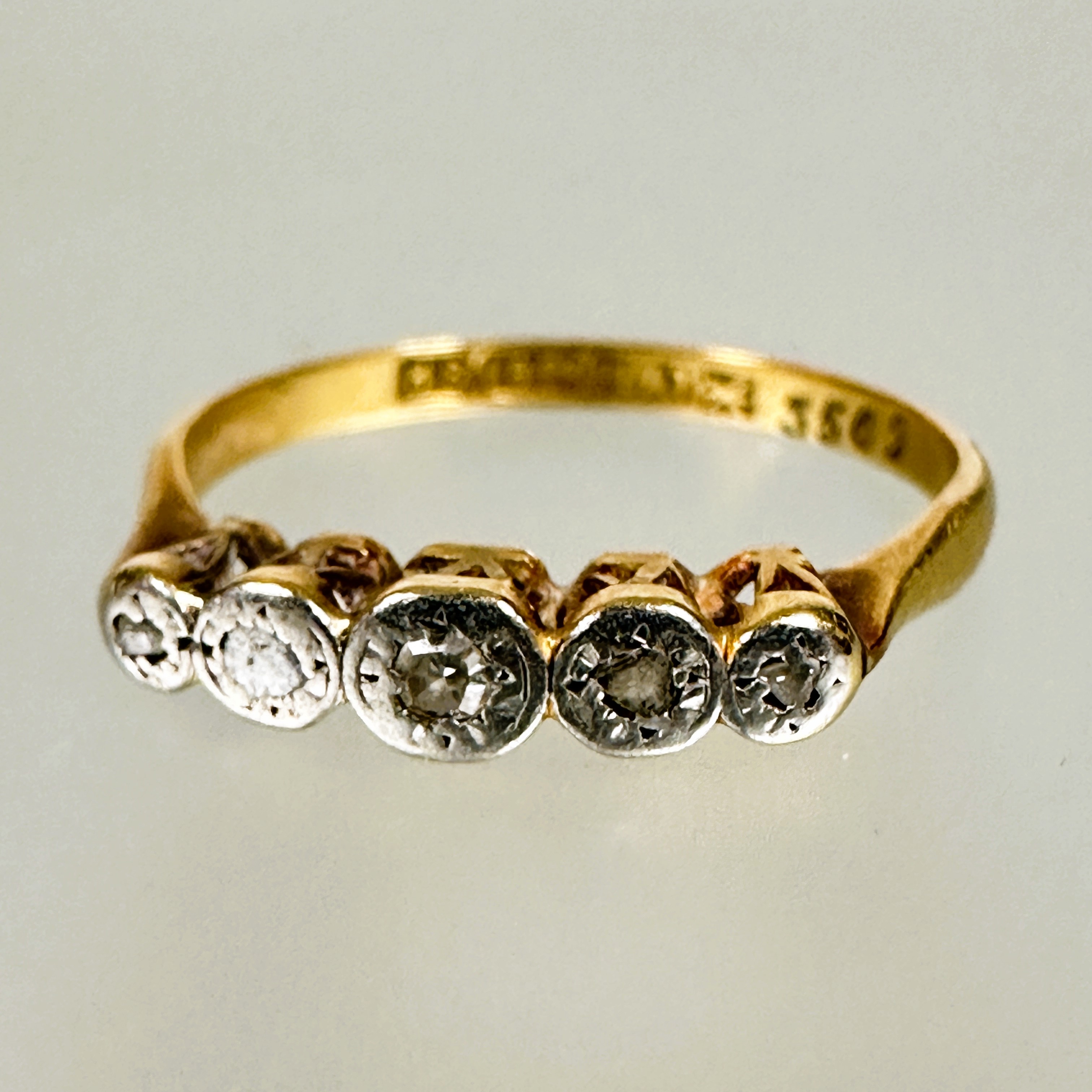 A Edwardian 18ct gold and platinum mounted four stone graduated diamond ring in rub over setting a/f