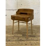 Ercol, an elm and beech writing desk, the superstructure with two drawers and open shelf, above a
