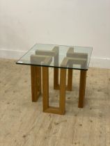 A contemporary lamp table, the square plate glass top raised on geometric square section supports.