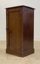 A Victorian stained pine bedside cupboard, the panelled door opening to a shelf behind, raised on