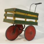 A child's toy push along trolley, green and gilt painted pine / plywood, with push handle and