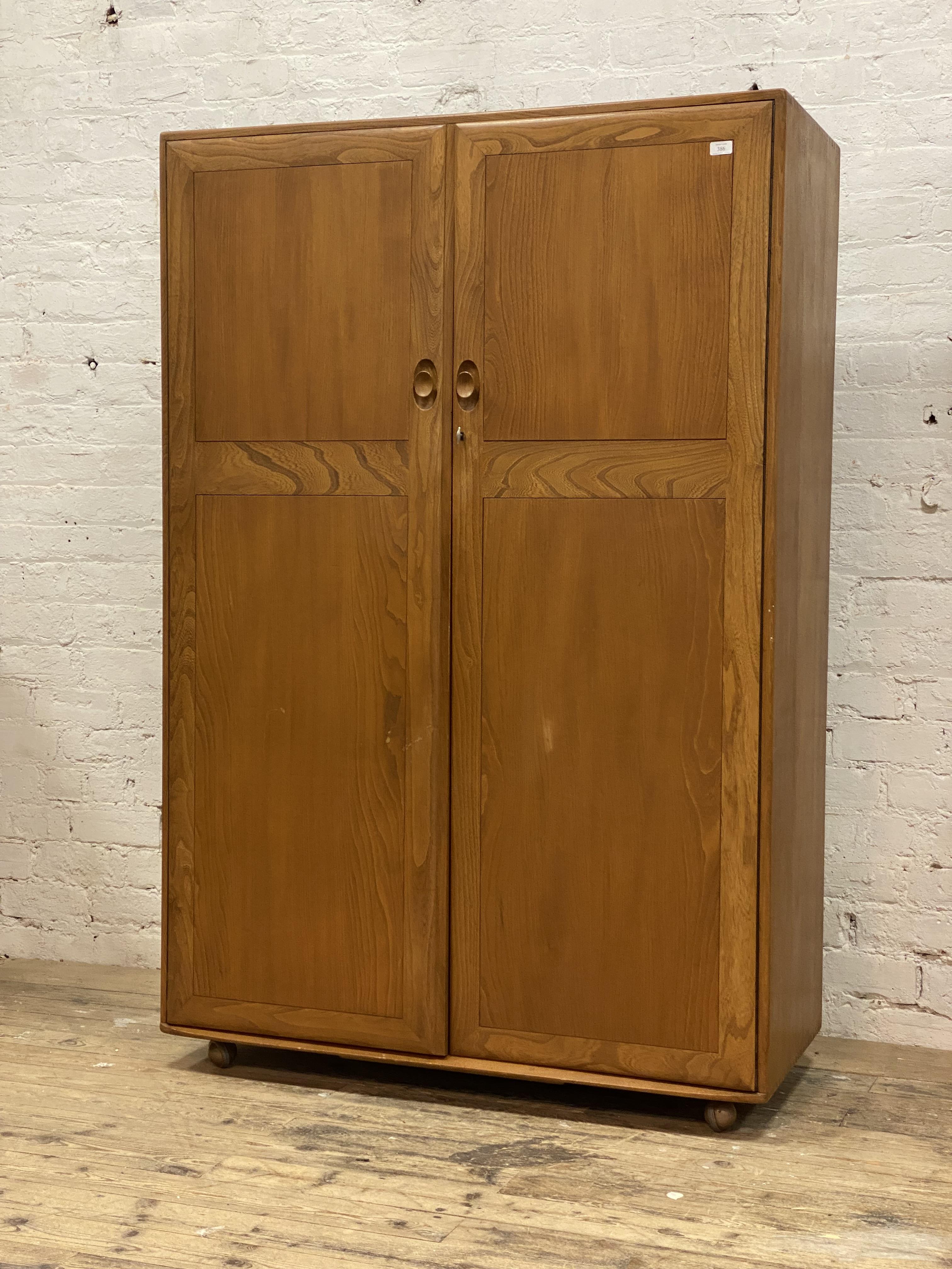 Ercol, a beech and elm double wardrobe, the two twin panel doors opening to an interior fitted for