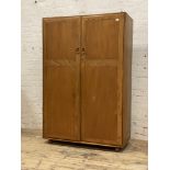 Ercol, a beech and elm double wardrobe, the two twin panel doors opening to an interior fitted for