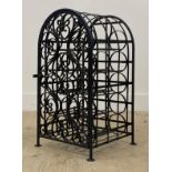A wrought metal wine rack of arched form, decorated with scrolls. H69cm.