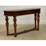 A traditional console table, fitted with a drawer and raised on turned supports united by an under