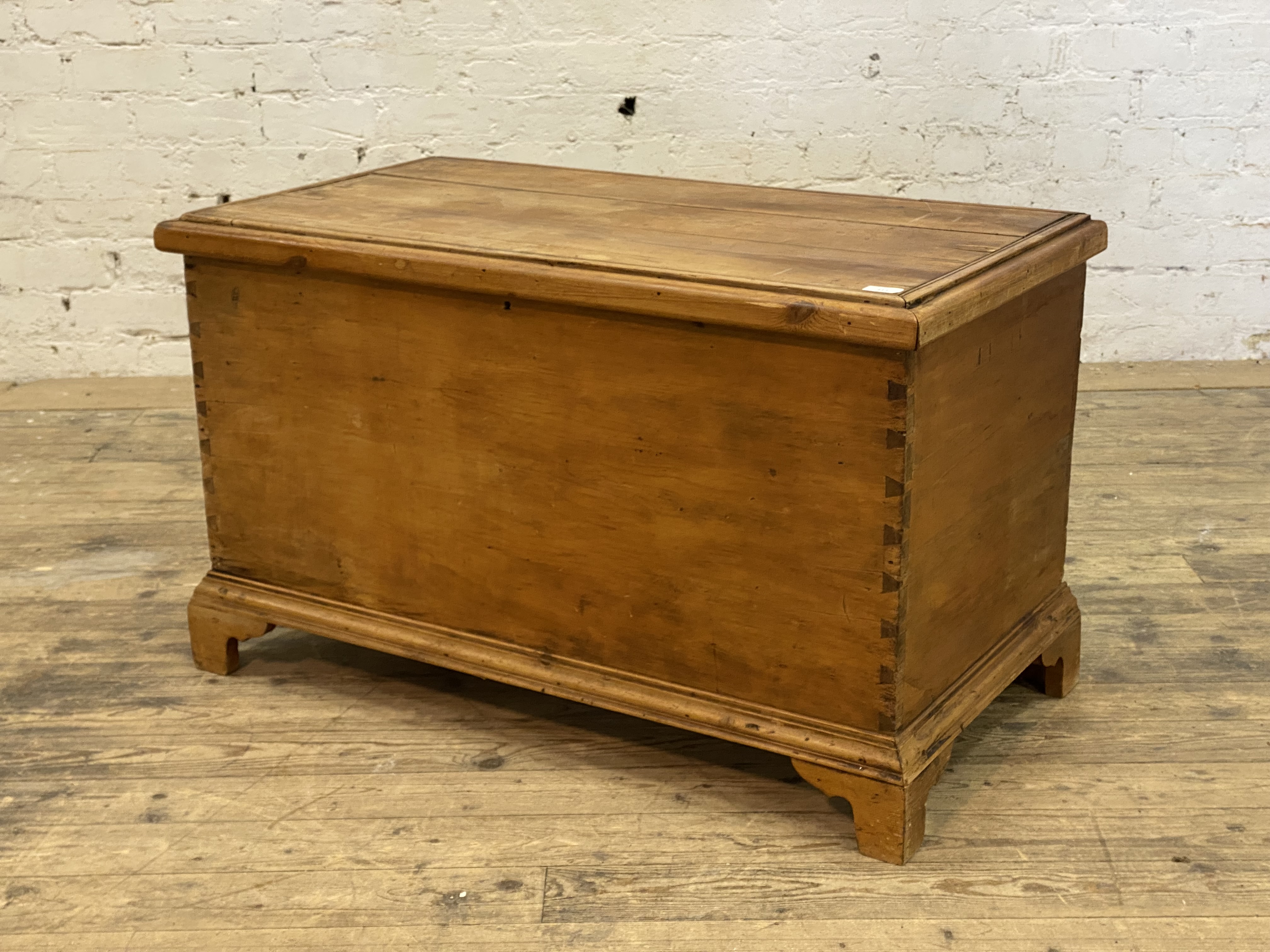 A Victorian pine blanket box, with dovetail joints and raised on bracket supports. H62cm, W105cm,