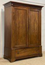 An Edwardian mahogany wardrobe, the projecting cornice above two panelled doors enclosing an