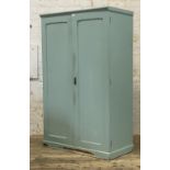 An early 20th century oak cupboard, later painted in blue, with two panelled doors enclosing an