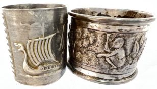 An Indian white metal repousse napkin ring decorated with figural scenes (vacant cartouche),