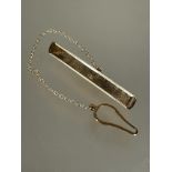 A modern 9ct gold tie clip with stamped border and safety chain and button loop L x 5.2g 3.34g