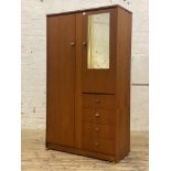 A mid century teak wardrobe by Symbol, full length door opening to an interior fitted with hanging