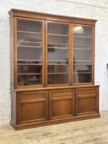 A Edwardian law office mahogany two part bookcase, the projecting cornice above figured frieze and