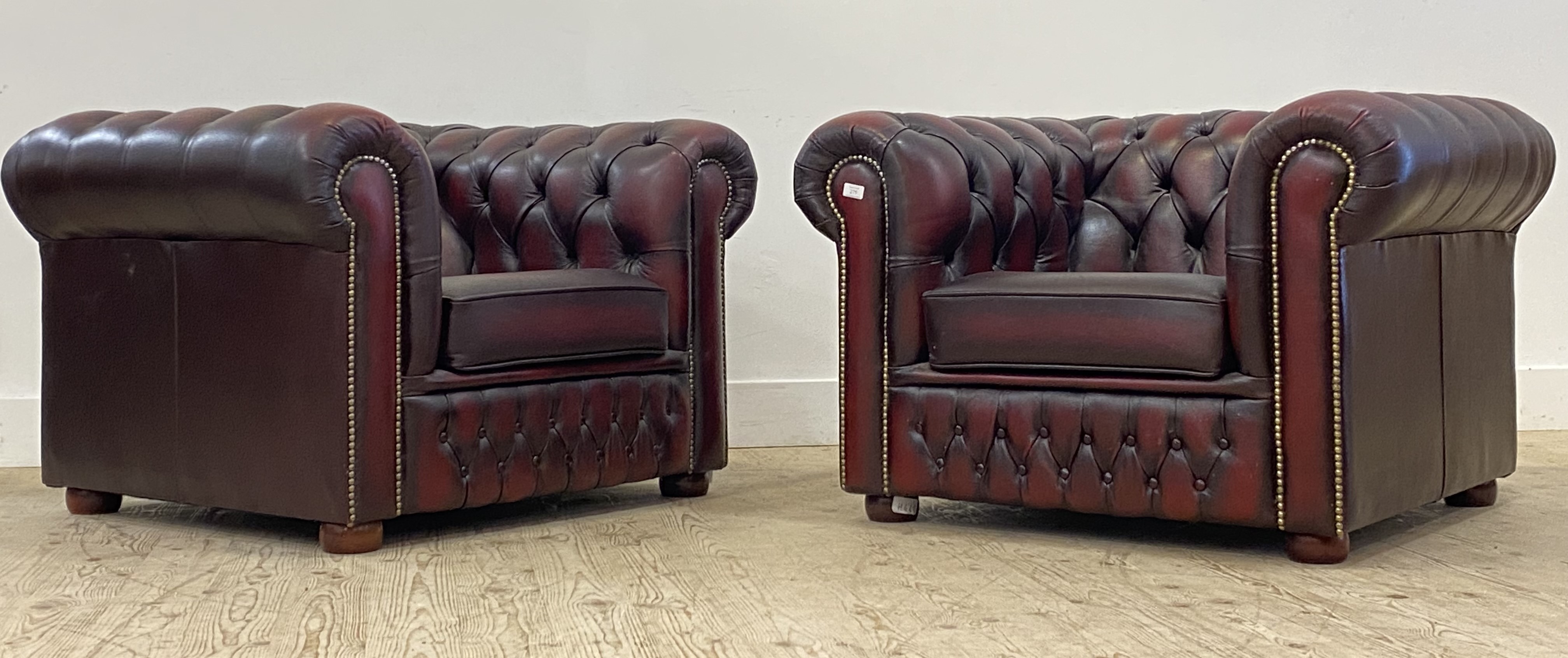 A pair of Vintage chesterfield club chairs, upholstered in deep buttoned oxblood leather. H70cm,