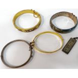 A group of four bangles comprising a Smith and Ewen Chester hallmarked silver bangle, two gold