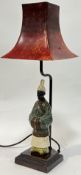 An patinated cast metal OKA lamp modelled as a Chinese scholar with red tapered shade (h- 49cm)