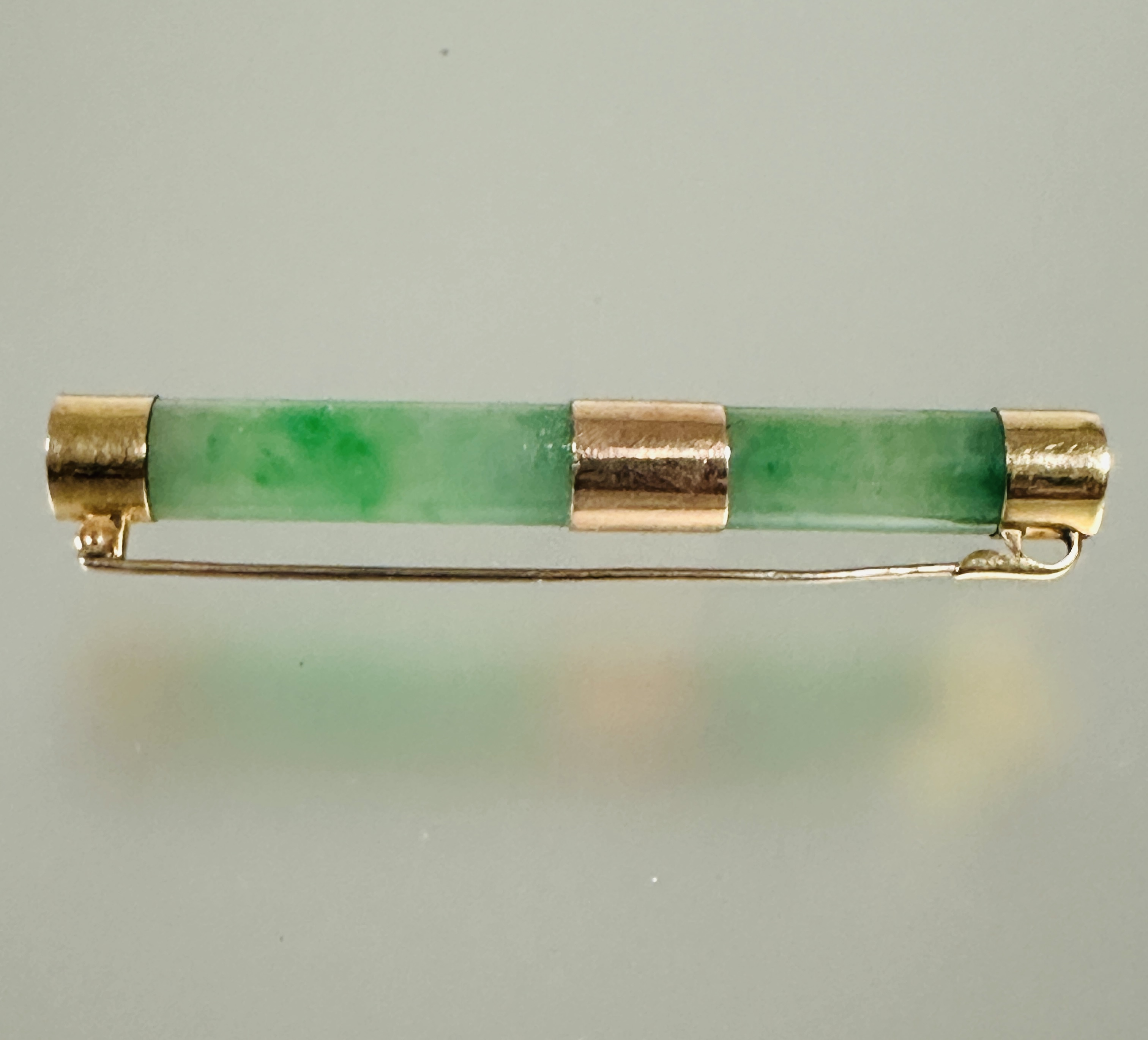 A Chinese 22ct gold mounted celadon jadeite barrel brooch with original clasp fastening shows no - Image 3 of 4