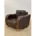 A contemporary brown leather upholstered armchair, raised on block supports. H87cm, 97cm x 97cm.