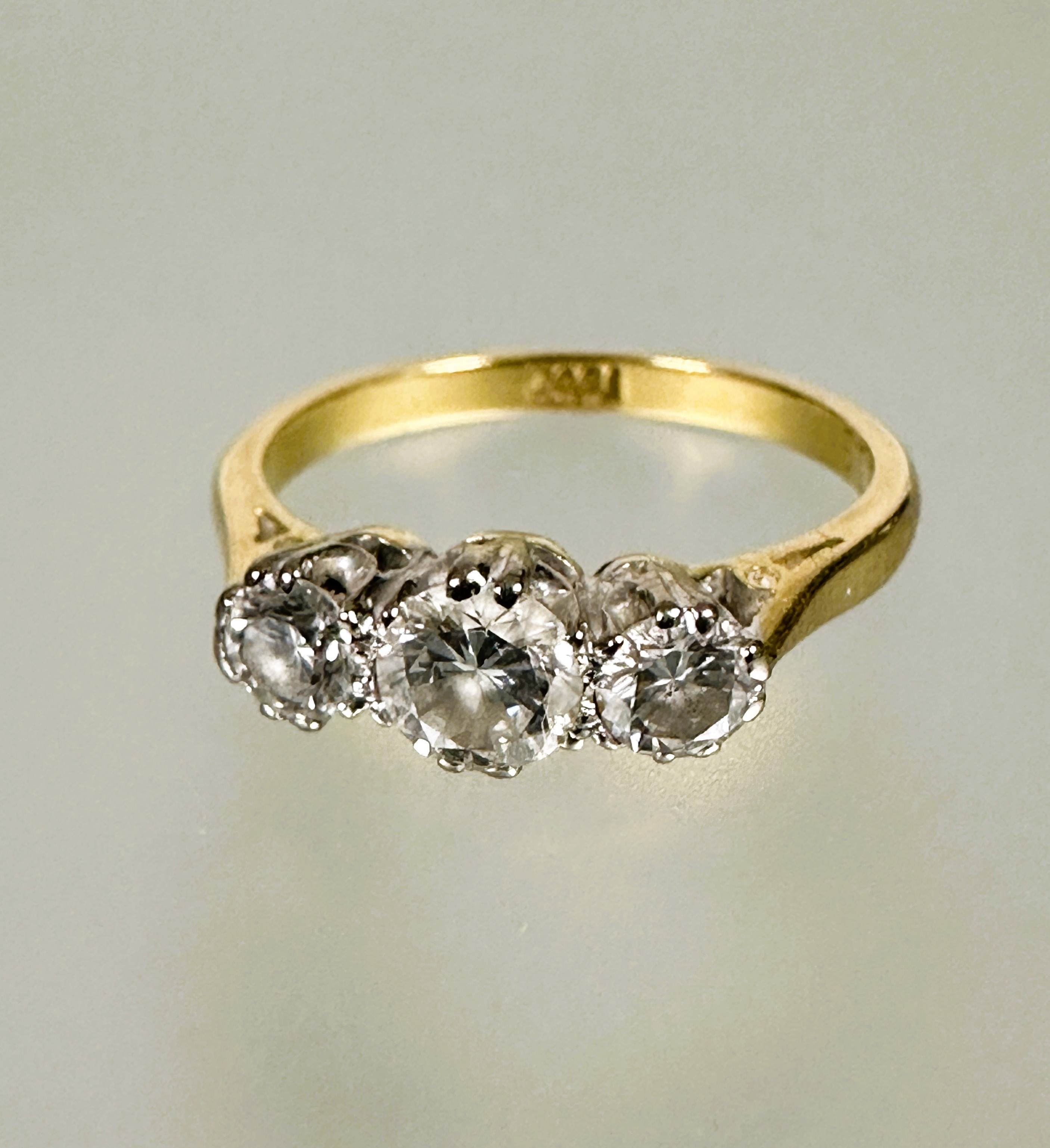 A 18ct gold three stone graduated diamond ring the center stone approximately 0.25ct flanked by 0.