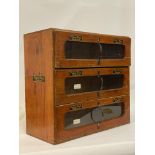 An early 20th century stained ash / oak counter top show case, fitted with three glazed drawers