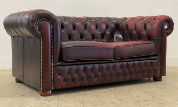 A vintage chesterfield two seat sofa, upholstered in deep buttoned oxblood leather. H70cm, L155cm,