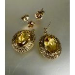 A pair of yellow metal oval chased drop earrings set pale yellow faceted citrines L x 2.5cm one