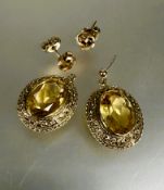 A pair of yellow metal oval chased drop earrings set pale yellow faceted citrines L x 2.5cm one