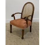 An early 20th century stained beech open armchair, with arched cane panel back above acanthus carved
