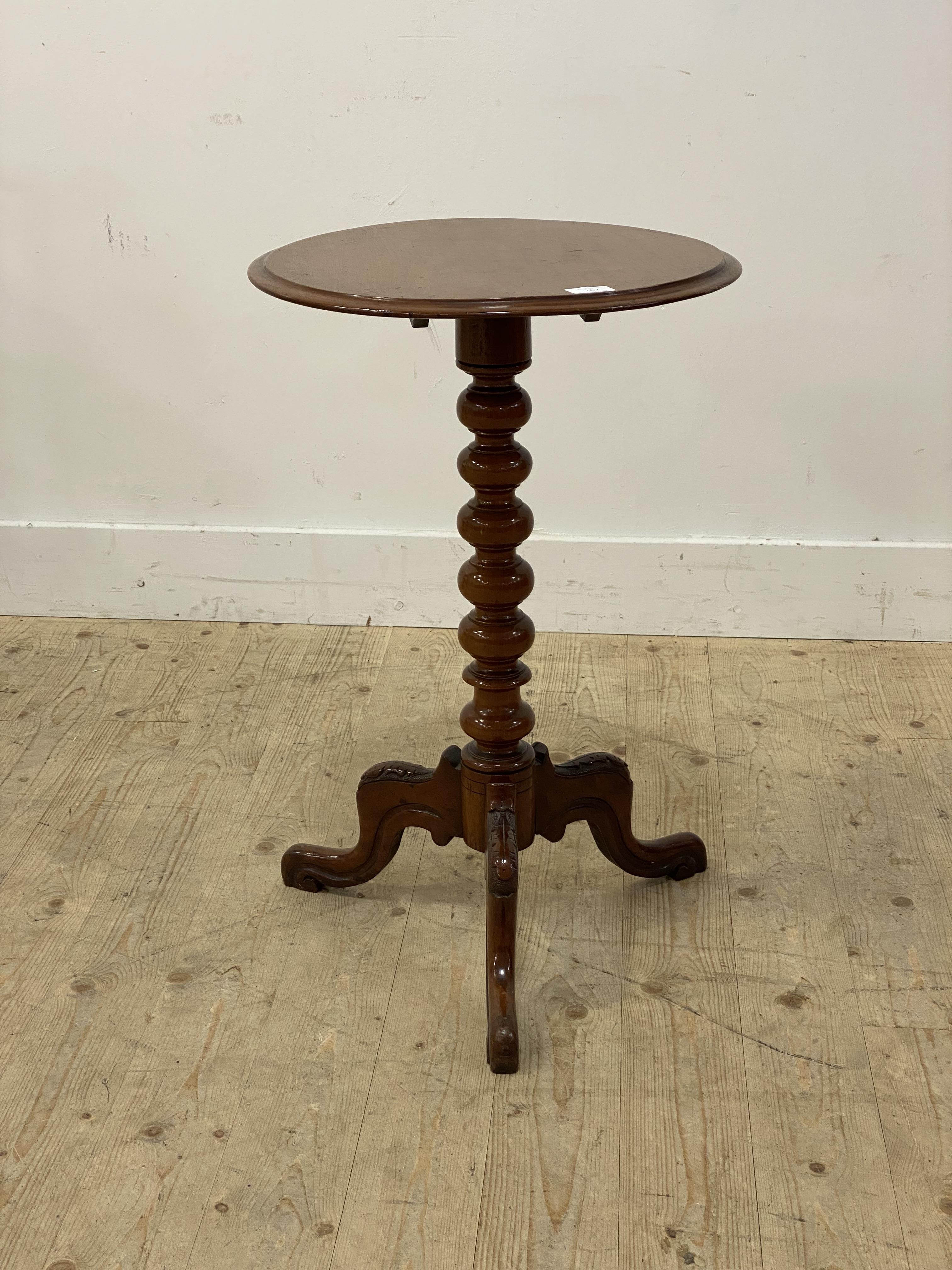 A Victorian walnut wine table, the circular tilt top raised on a bobbin turned column and three