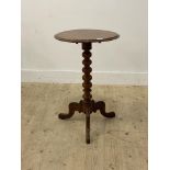 A Victorian walnut wine table, the circular tilt top raised on a bobbin turned column and three