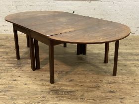 A George III mahogany dining table, each end with a demi-lune drop leaf and raised on square moulded