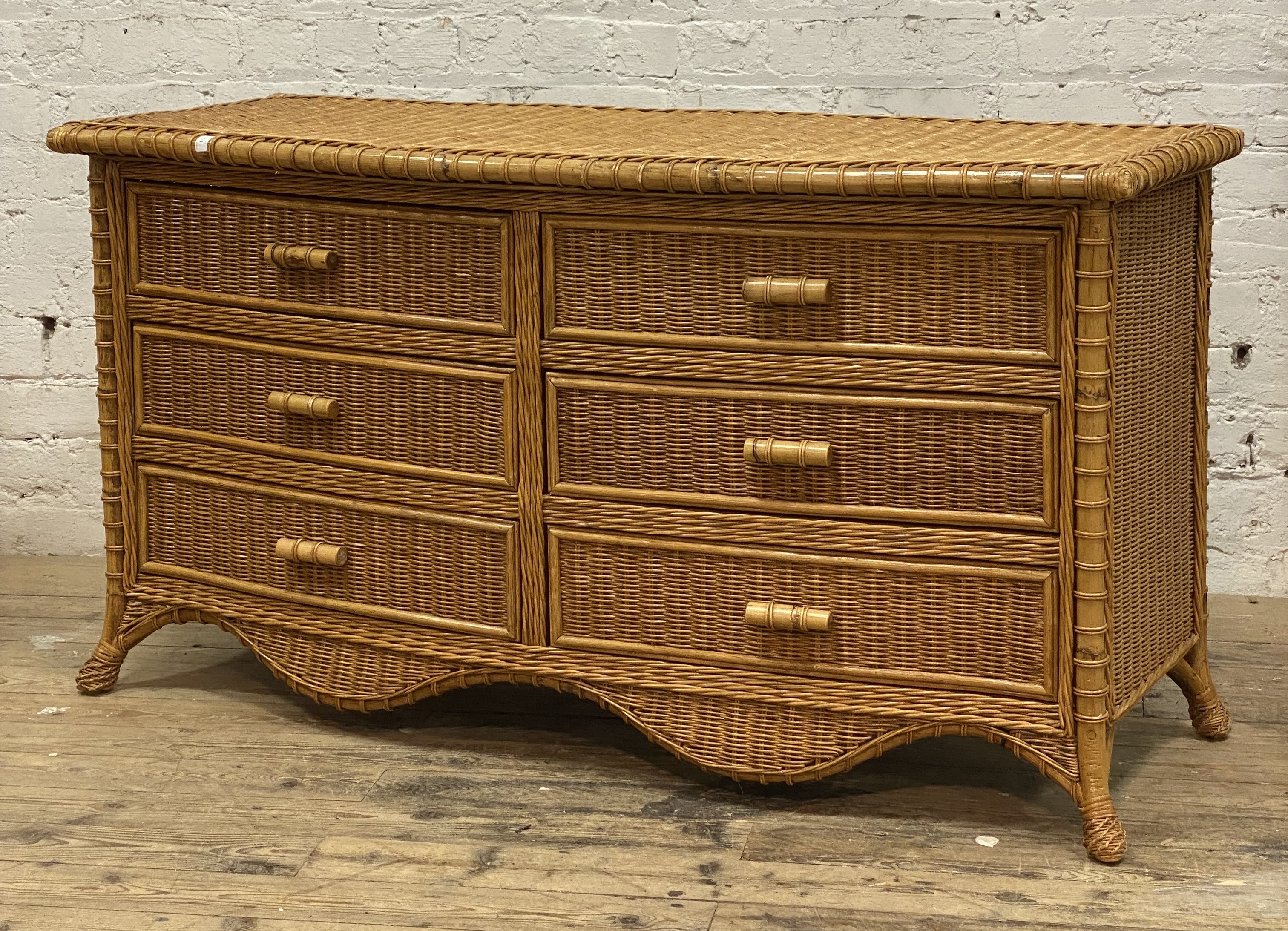 A vintage rattan and bamboo bow front sideboard, fitted with six drawers above a shaped apron and