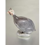 A Danish Royal Copenhagen porcelain figure of a Guineafowl decorated with polychrome enamels on oval