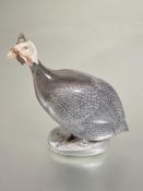 A Danish Royal Copenhagen porcelain figure of a Guineafowl decorated with polychrome enamels on oval