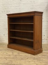 An Edwardian walnut open bookcase, with a figured frieze above three adjustable shelves, raised on a