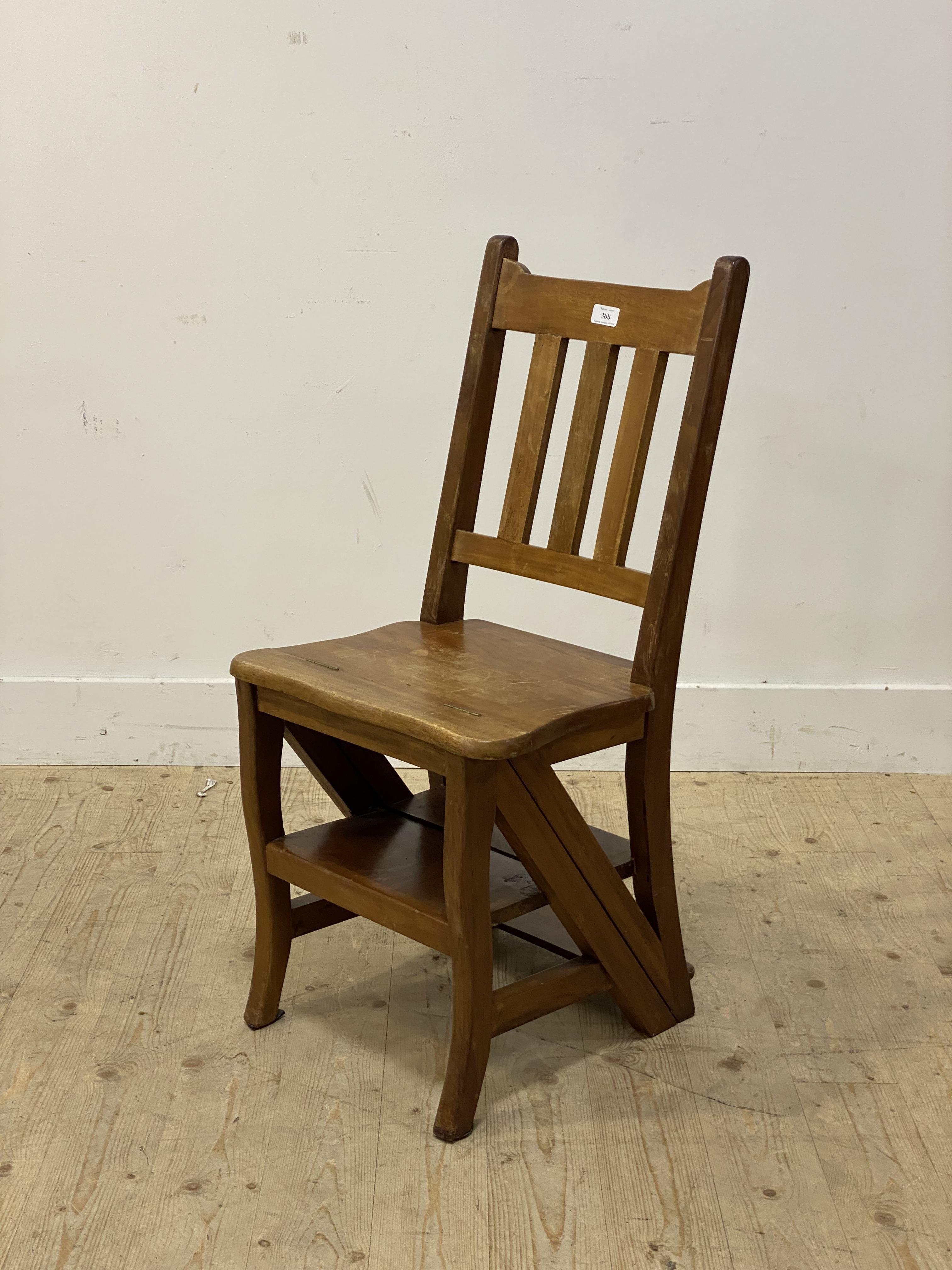 A Walnut metamorphic library chair, the the spar back and shaped seat folding over to a three rung