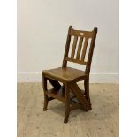 A Walnut metamorphic library chair, the the spar back and shaped seat folding over to a three rung