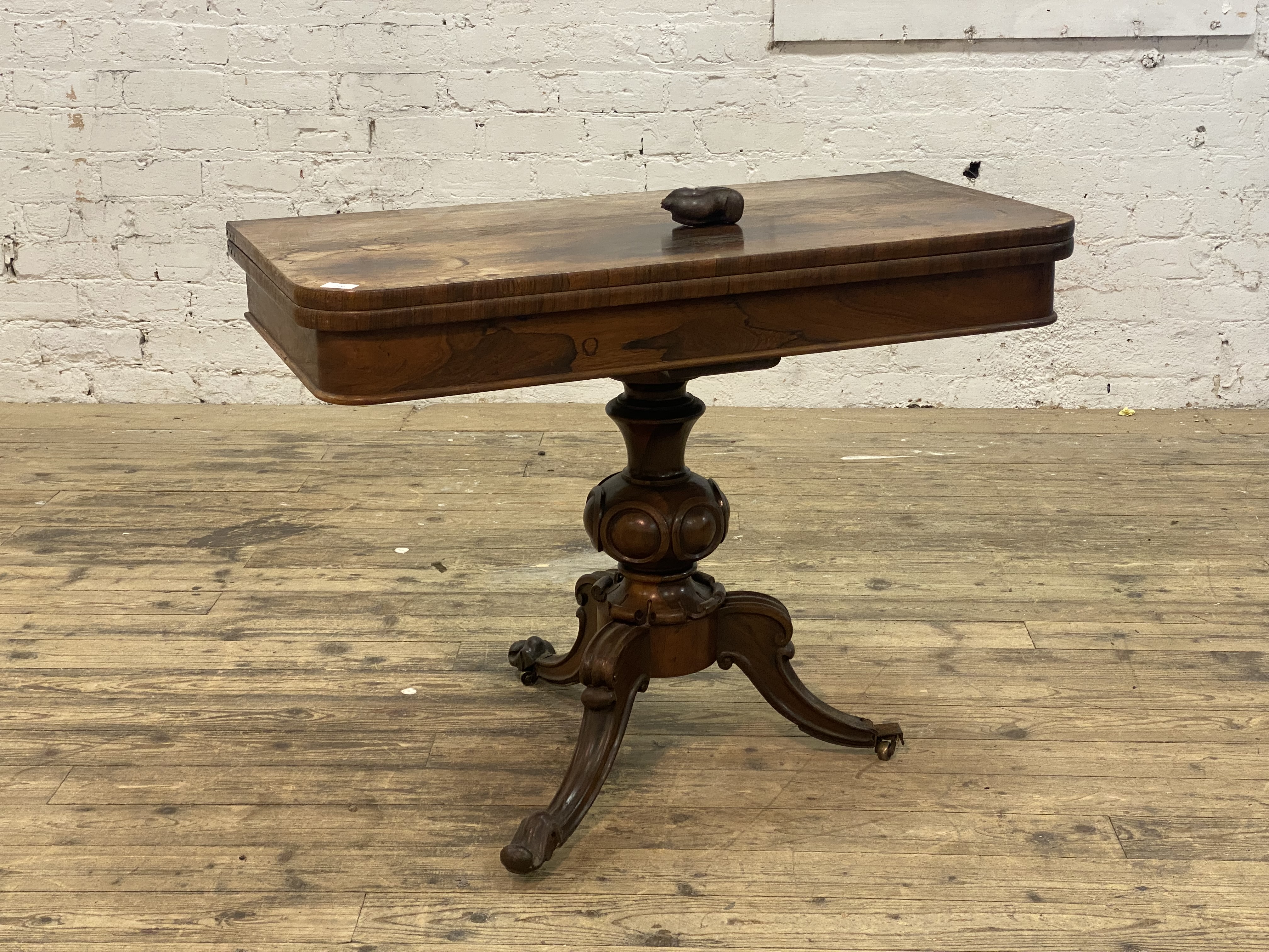 An early Victorian rosewood fold over tea table, the rectangular top above a plain frieze, raised on