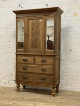 An Edwardian stained wood cabinet on chest, the projecting cornice above a floral incise carved